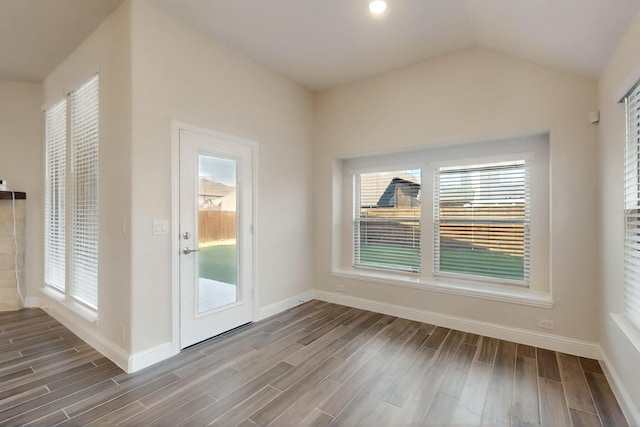doorway featuring wood finished floors, baseboards, and lofted ceiling
