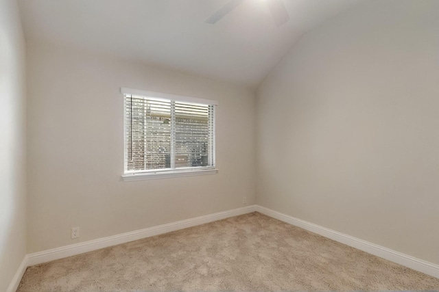carpeted empty room with lofted ceiling, ceiling fan, and baseboards