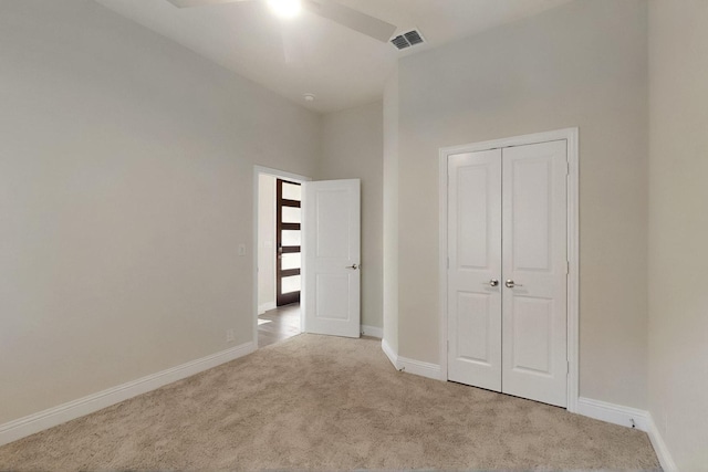 unfurnished bedroom featuring carpet, baseboards, a closet, and ceiling fan