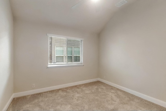 carpeted spare room with lofted ceiling and baseboards
