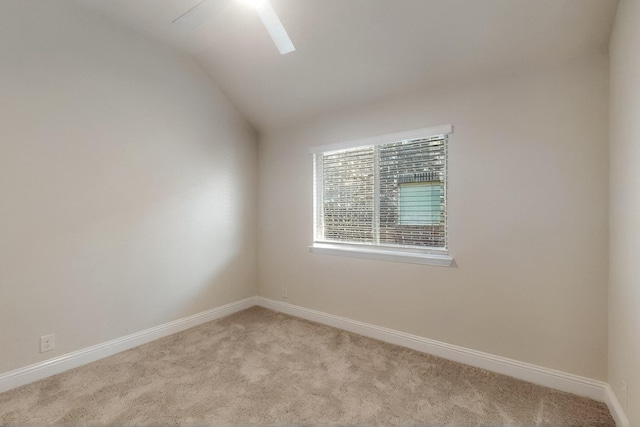unfurnished room with light carpet, vaulted ceiling, and baseboards
