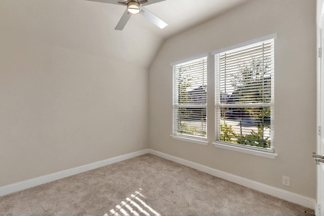 unfurnished room featuring carpet, a ceiling fan, baseboards, and vaulted ceiling