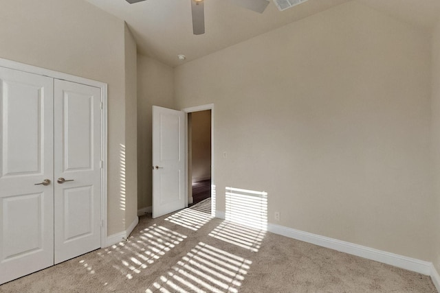 unfurnished bedroom with carpet flooring, baseboards, a closet, lofted ceiling, and ceiling fan