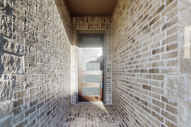 doorway to property featuring brick siding