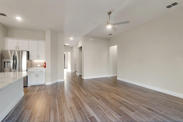 unfurnished living room with wood finished floors, ceiling fan, baseboards, and recessed lighting
