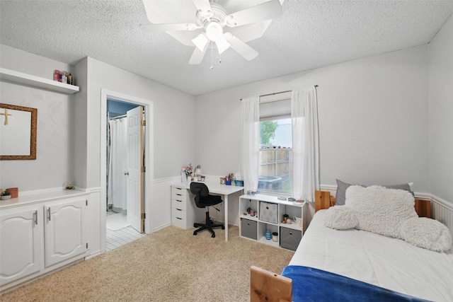 2606 N Carroll Ave, Southlake, TX 76092 - bedroom featuring a textured ceiling, a wainscoted wall, and a ceiling fan