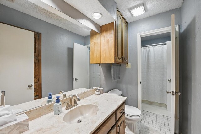 2606 N Carroll Ave, Southlake, TX 76092 - bathroom featuring toilet, vanity, tile patterned flooring, a textured ceiling, and a shower with curtain