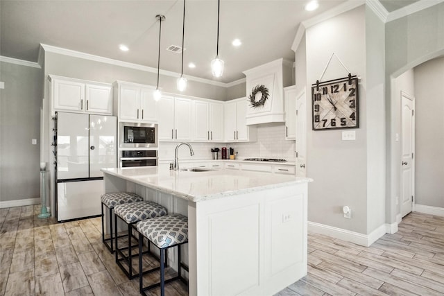 1456 Silent Springs Dr, Fort Worth, TX 76052 - kitchen featuring appliances with stainless steel finishes, a sink, wood tiled floors, a breakfast bar area, and white cabinetry