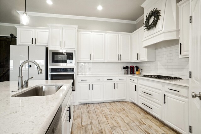 1456 Silent Springs Dr, Fort Worth, TX 76052 - kitchen with a sink, custom range hood, stainless steel appliances, ornamental molding, and white cabinetry
