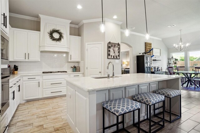 1456 Silent Springs Dr, Fort Worth, TX 76052 - kitchen with a sink, arched walkways, gas stovetop, tasteful backsplash, and an island with sink