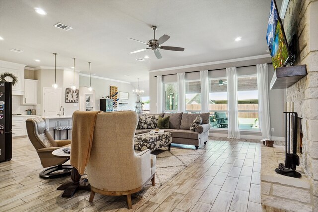 1456 Silent Springs Dr, Fort Worth, TX 76052 - living room with a ceiling fan, crown molding, a chandelier, light wood-type flooring, and a stone fireplace