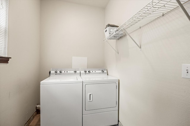 laundry room featuring washing machine and dryer and baseboards
