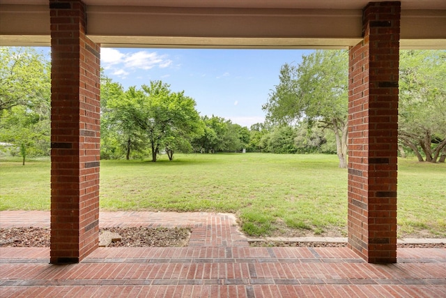 view of green lawn with view of wooded area