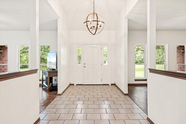 foyer entrance featuring a chandelier and baseboards