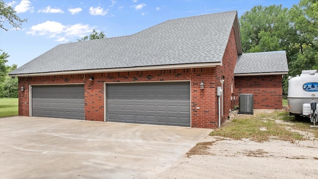 view of side of property with cooling unit, roof with shingles, brick siding, and driveway