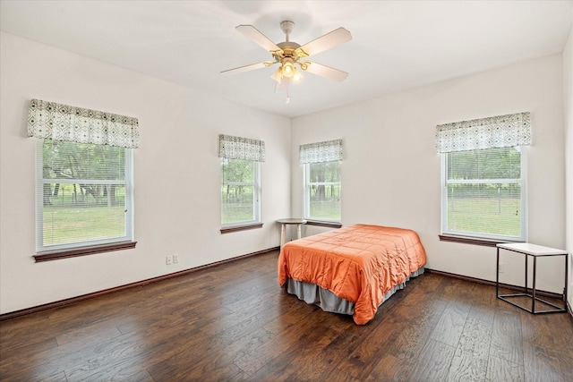 bedroom with wood-type flooring, a ceiling fan, and baseboards