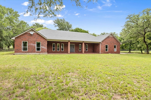 back of property featuring a yard and brick siding