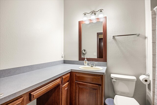 bathroom featuring vanity, toilet, and a shower