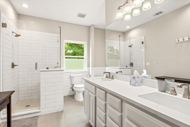 full bath featuring toilet, a shower stall, double vanity, and tile patterned flooring