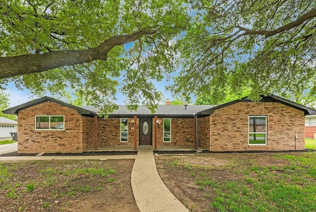 ranch-style house featuring brick siding