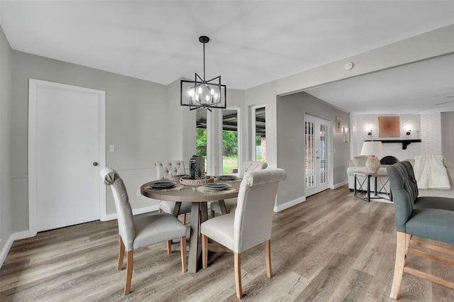 dining area with wood finished floors, a chandelier, and baseboards