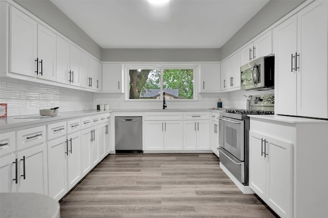 kitchen featuring appliances with stainless steel finishes, light countertops, and white cabinetry