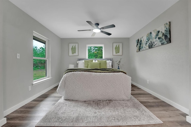 bedroom with baseboards, wood finished floors, and ceiling fan