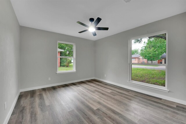 unfurnished room featuring wood finished floors, a ceiling fan, and baseboards