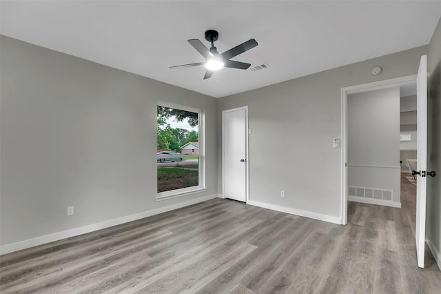 unfurnished bedroom featuring wood finished floors, baseboards, and a ceiling fan