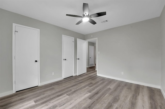 unfurnished bedroom featuring wood finished floors, baseboards, and ceiling fan