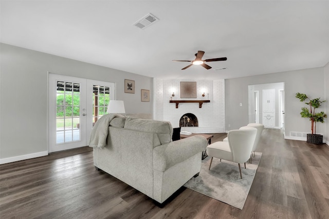 living area featuring a brick fireplace, dark wood-style floors, and baseboards