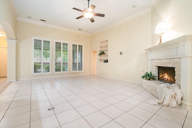 842 Turquoise Pt, Rockwall, TX 75032 - unfurnished living room featuring built in features, a fireplace, ceiling fan, light tile patterned floors, and arched walkways