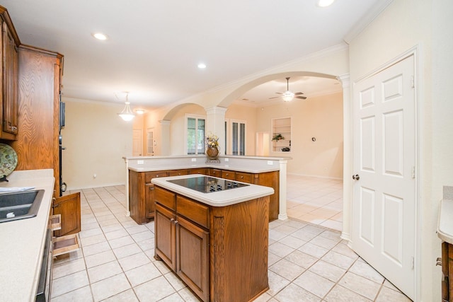 842 Turquoise Pt, Rockwall, TX 75032 - kitchen with a kitchen island, black electric cooktop, light tile patterned flooring, brown cabinetry, and ornate columns