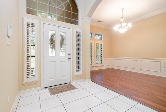 842 Turquoise Pt, Rockwall, TX 75032 - entrance foyer featuring light tile patterned floors, a chandelier, crown molding, and arched walkways