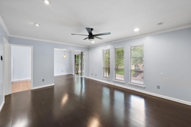 empty room featuring ceiling fan, healthy amount of natural light, wood finished floors, baseboards, and ornamental molding