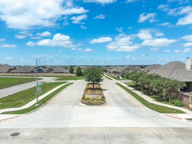 1713 Victoria Dr, Fort Worth, TX 76131 - view of concrete street featuring sidewalks, street lights, a residential view, and curbs