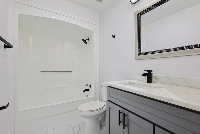 bathroom featuring marble finish flooring, toilet, vanity, and bathtub / shower combination