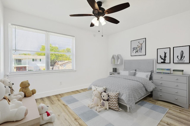 bedroom featuring baseboards, wood finished floors, and a ceiling fan