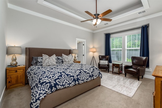 carpeted bedroom featuring a tray ceiling, a ceiling fan, and baseboards