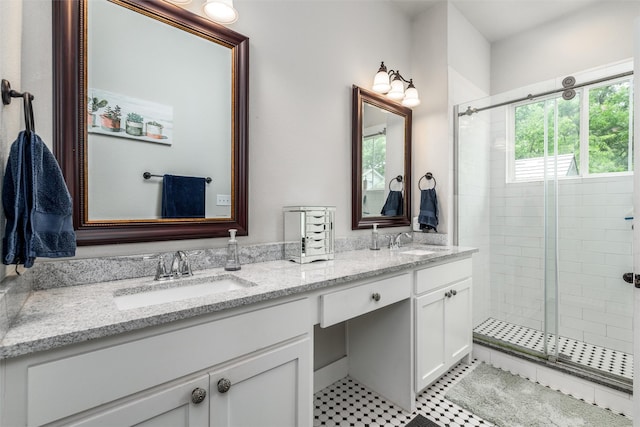 bathroom with a shower stall, double vanity, and tile patterned flooring
