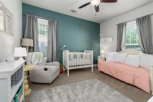 carpeted bedroom with multiple windows and a ceiling fan