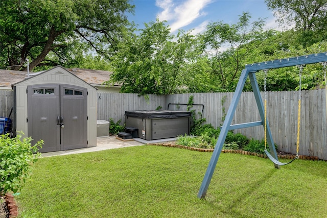 view of yard with a hot tub, a shed, an outbuilding, and a patio area