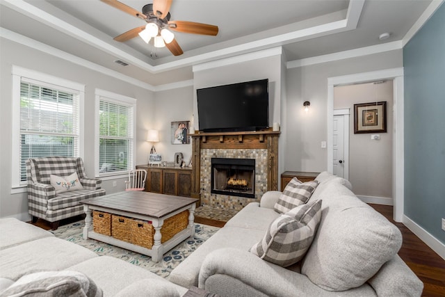 living room with a raised ceiling, a ceiling fan, wood finished floors, and baseboards