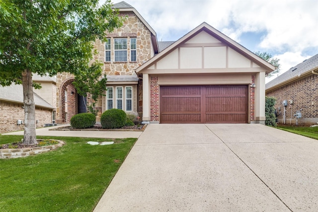 7333 Valencia Grove Ct, Fort Worth, TX 76132 - tudor home featuring an attached garage, concrete driveway, stone siding, a front yard, and brick siding