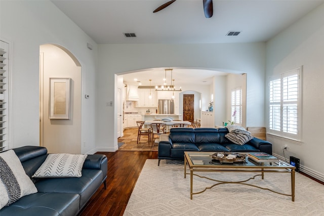 7333 Valencia Grove Ct, Fort Worth, TX 76132 - living room featuring arched walkways, dark wood-style flooring, ceiling fan, and baseboards