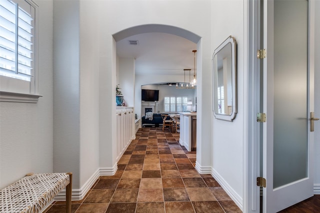 7333 Valencia Grove Ct, Fort Worth, TX 76132 - hallway with arched walkways, dark stone finish floors, and baseboards