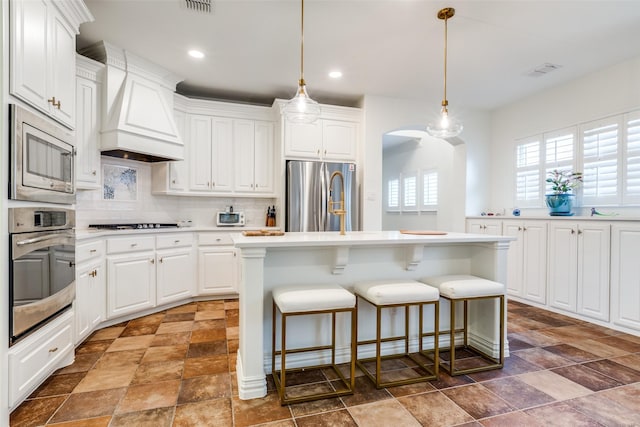 7333 Valencia Grove Ct, Fort Worth, TX 76132 - kitchen featuring appliances with stainless steel finishes, custom range hood, stone finish floors, decorative backsplash, and light countertops