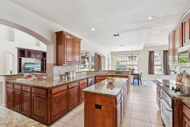 509 Wentworth Ln, Murphy, TX 75094 - kitchen with appliances with stainless steel finishes, a sink, arched walkways, a peninsula, and a chandelier