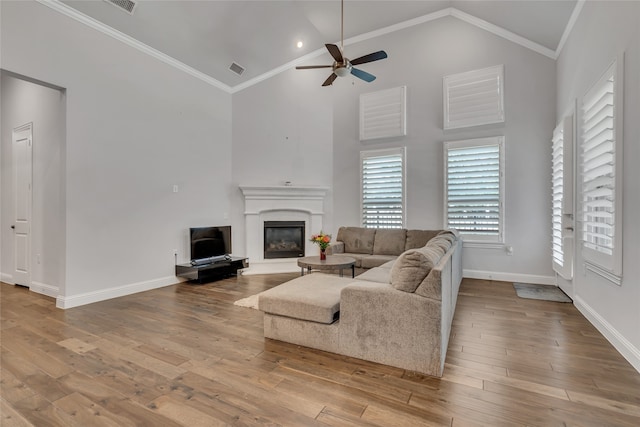 175 Calla Dr, Flower Mound, TX 75028 - living area with ceiling fan, a glass covered fireplace, wood finished floors, baseboards, and high vaulted ceiling