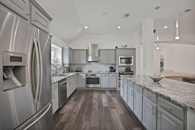 10108 Morning Glory Ln, Frisco, TX 75035 - kitchen with appliances with stainless steel finishes, gray cabinetry, wall chimney exhaust hood, a sink, and lofted ceiling
